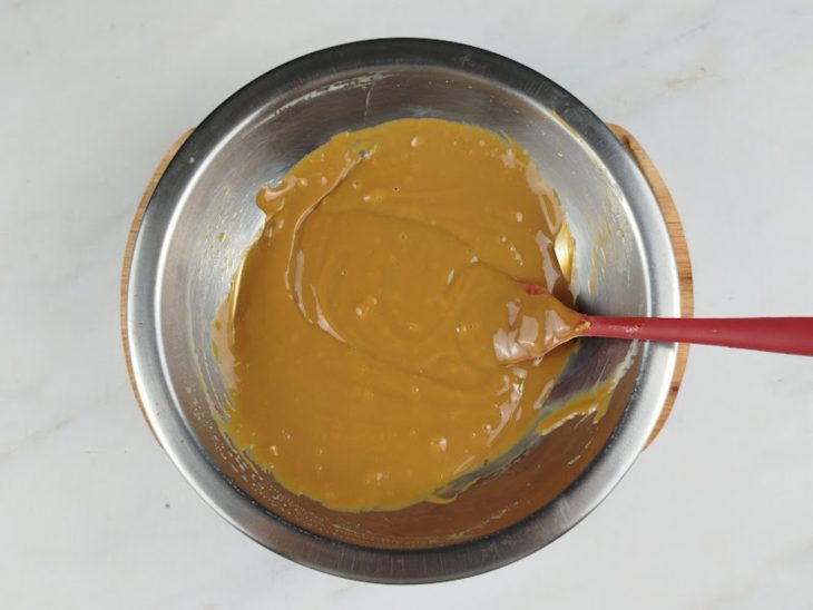 Creme de leite e doce de leite misturados em um recipiente de alumínio.