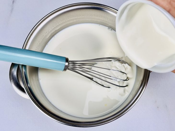 Amido de milho, leite, leite condensado e creme de leite em uma panela.