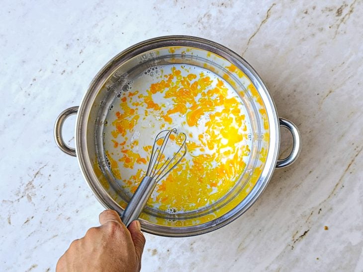 Ingredientes do creme branco sendo misturados na panela.