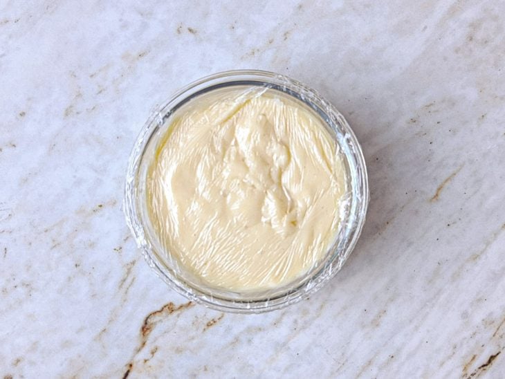 Creme branco sendo levado ao fogo e mexido até engrossar.