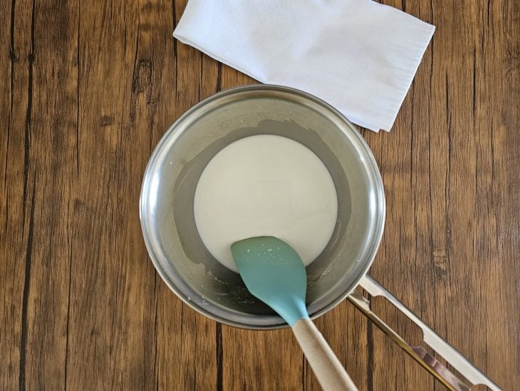 Uma panela contendo a mistura de leite e amido de milho.