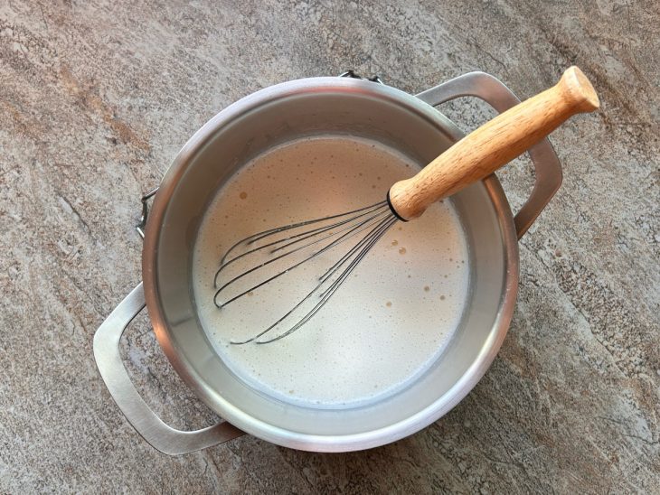 Sob a mesa, uma panela com os ingredientes a serem fervidos.