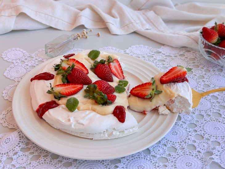 Pavlova cortada e uma fatia sendo servida.