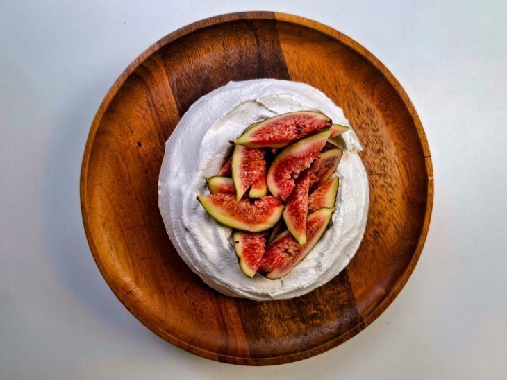 Pavlova preenchida com iogurte e finalizada com pedaços de figo na superfície.