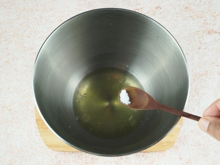 Claras e uma pitada de sal num recipiente.