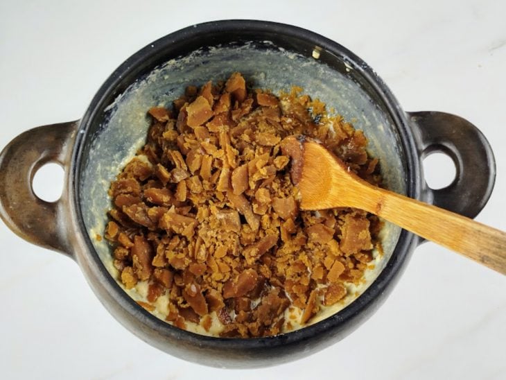 leite fervido e cremoso com adição de rapadura em lascas.