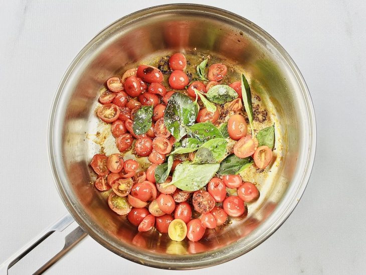 Na panela, os tomates cortados, junto aos temperos.