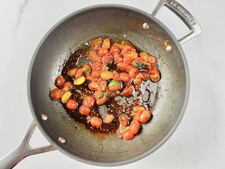 Os tomatinhos cereja na frigideira em que os frangos foram dourados.