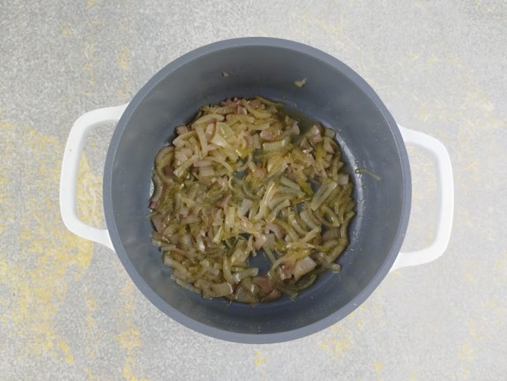 Cebola sendo refogada na manteiga até ficar macia.