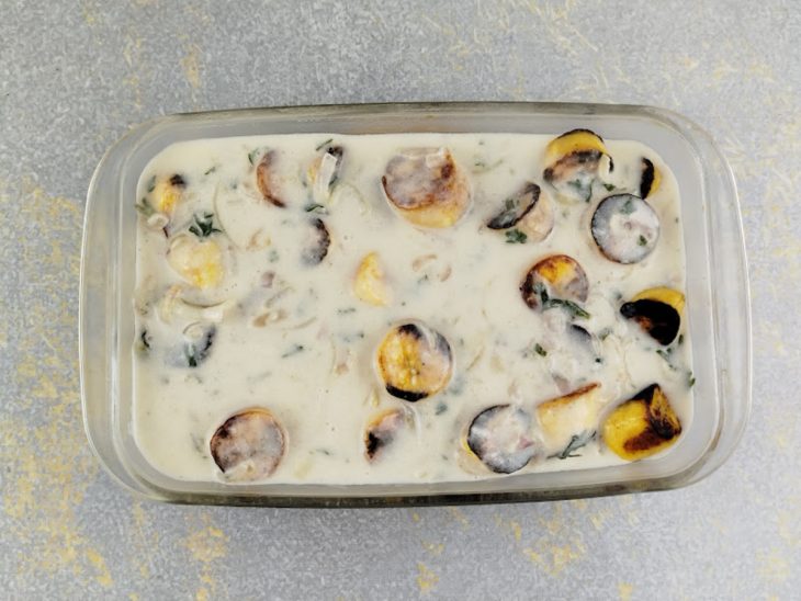 Montagem do prato com peixe, bananas e molho em um refratário.