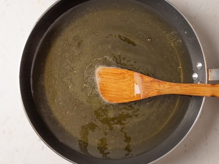 Panela com óleo quente e colher de pau.