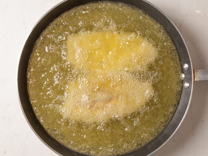 Filés de peixe fritando no óleo.