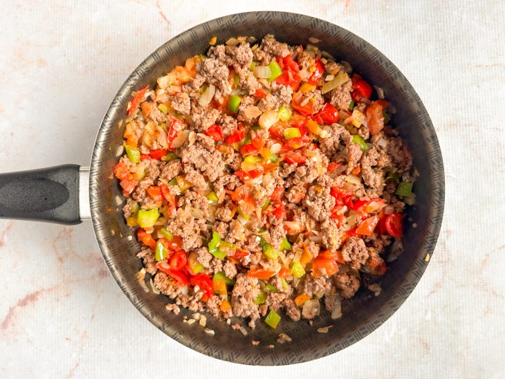 Adição de legumes picados à carne.