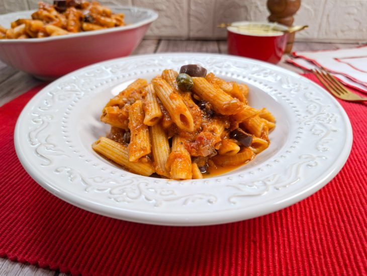 Penne alla puttanesca servido no prato.