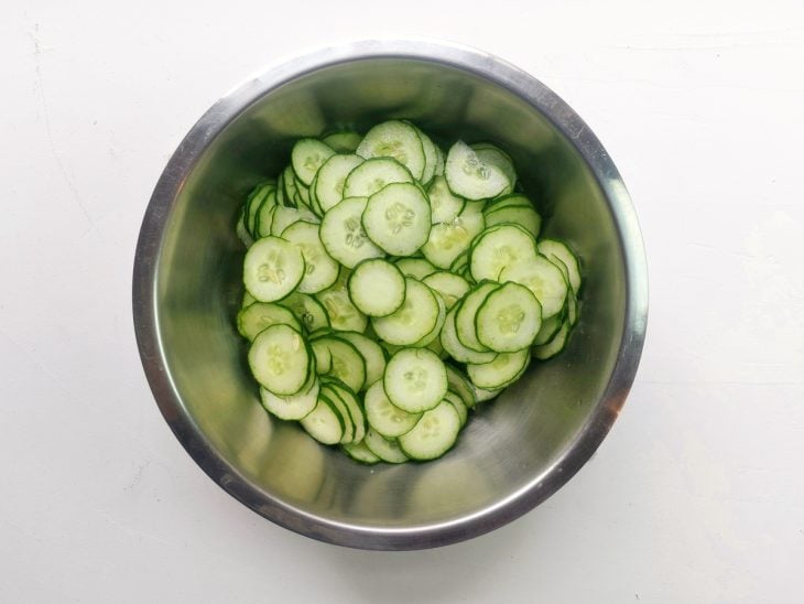 Um recipiente contendo pepino cortado em rodelas.
