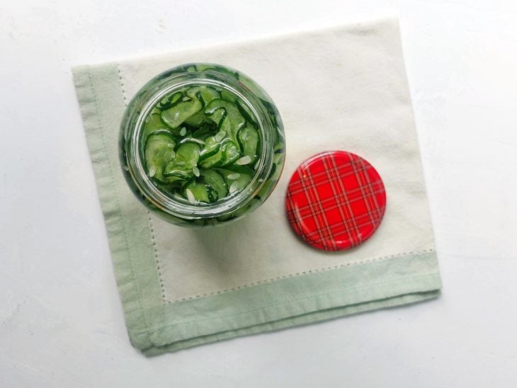 Um recipiente contendo pepino agridoce em conserva.