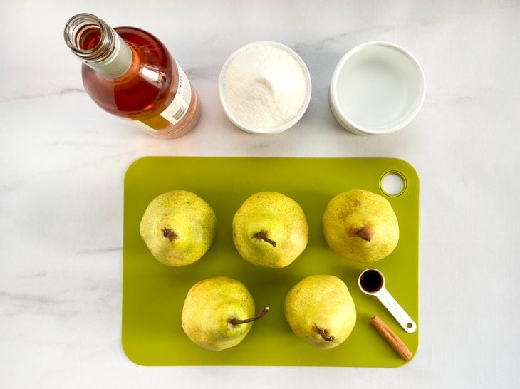 Ingredientes das peras ao vinho rosé reunidos na bancada.