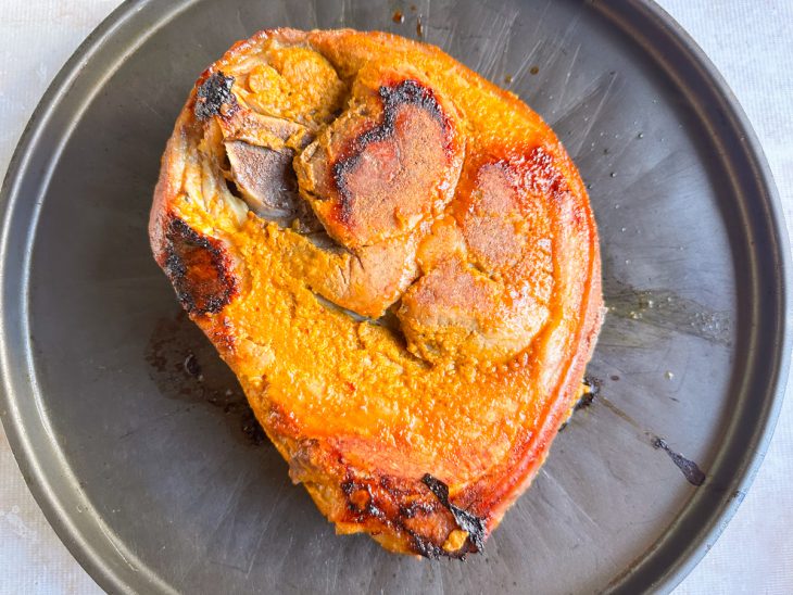 Pernil acomodado em uma forma rasa e redonda.