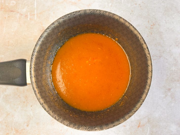 Caldo reduzido numa panela.