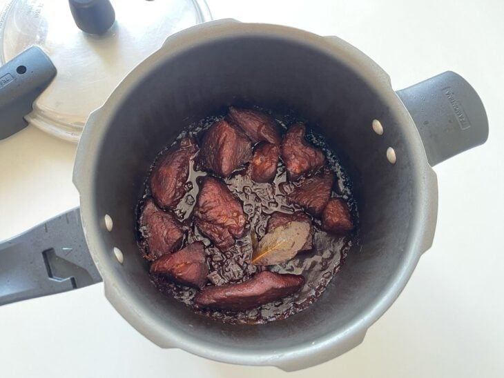 Panela de pressão tampada e travada cozinhando a receita em fogo médio.
