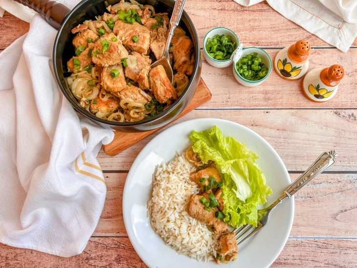 Carne pronta, servida em prato com acompanhamento de arroz e salada.