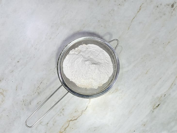 Ingredientes secos peneirados juntos em uma tigela.