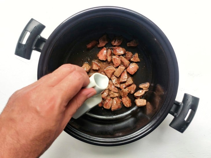 Água adicionada na panela com os pedacinhos de carne.