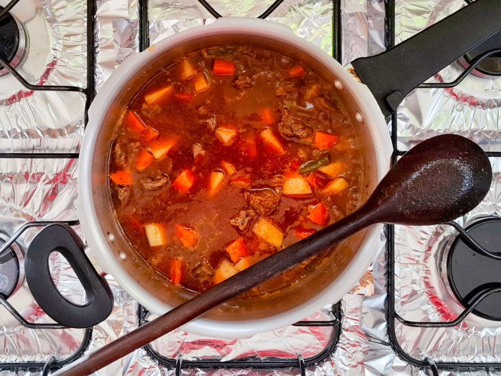 adição de batatas e cenoura picadas ao picadinho de carne.