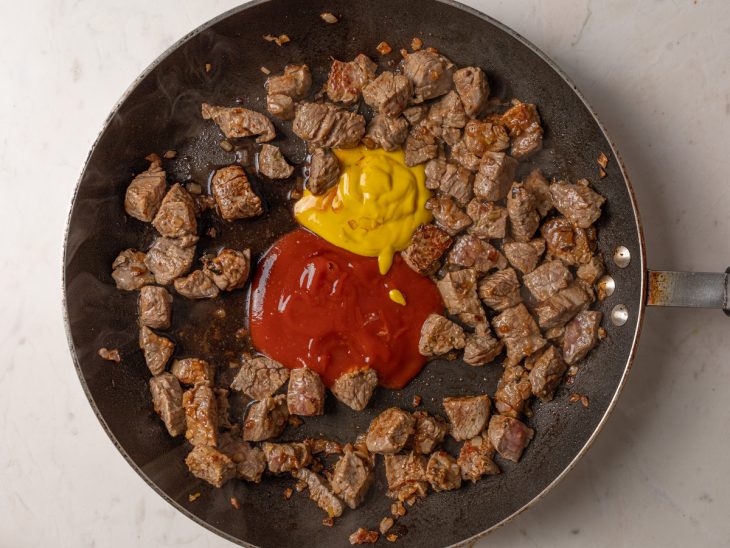 Ketchup, mostarda e molho inglês adicionados a panela.