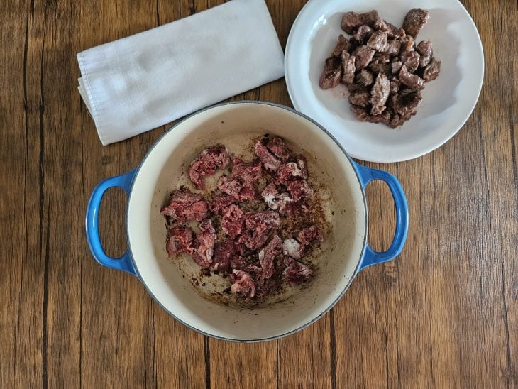 Panela com alguns cubos de mignon sendo selados e um recipiente ao lado com alguns cubos já dourados.