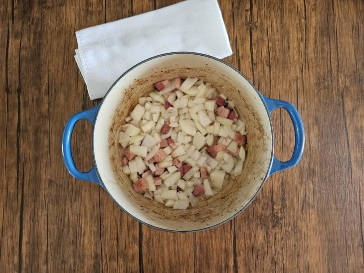 Panela com cubos de bacon e cebola.