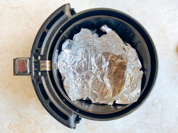 Papel alumínio acomodado no cesto da air fryer.