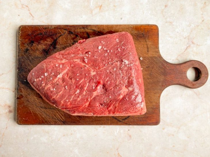 Numa tábua, picanha temperada com sal grosso e pimenta-do-reino.