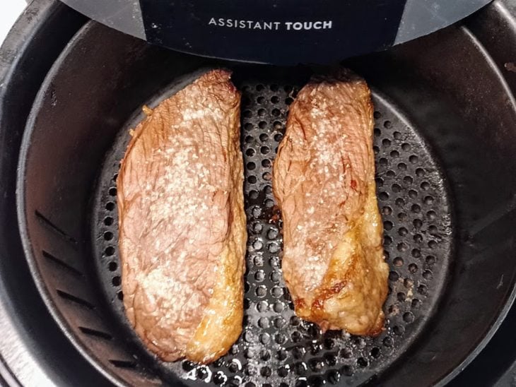 Bifes de picanha em um cesto de airfryer.