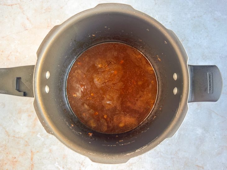 Molho reduzindo com a tampa aberta após o cozimento.