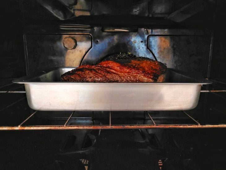 Uma peça de picanha no forno assando.