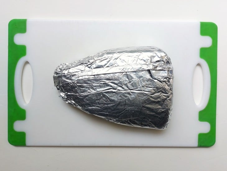 Uma peça de picanha suína embrulhada no papel alumínio.