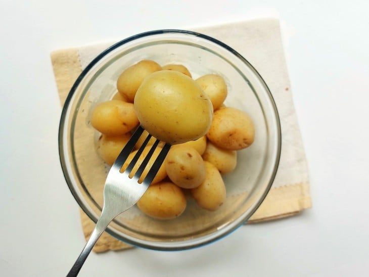 Um recipiente contendo batatas-bolinhas cozidas al dente.