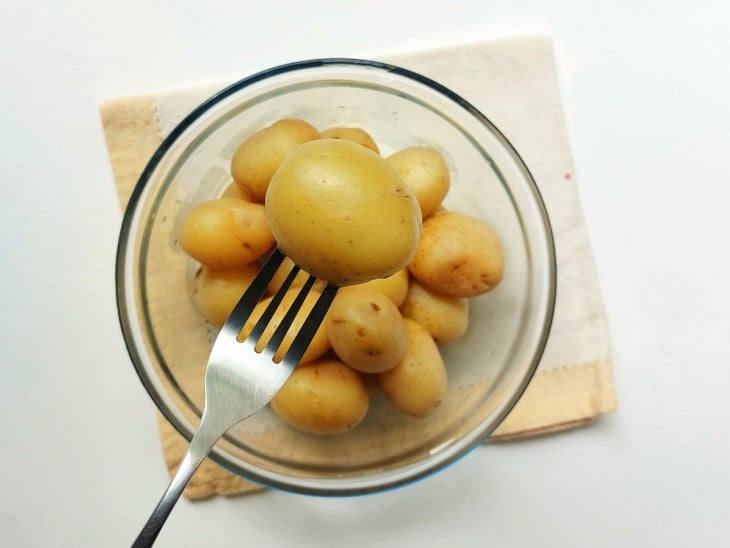 Um recipiente contendo batatas-bolinhas cozidas al dente.