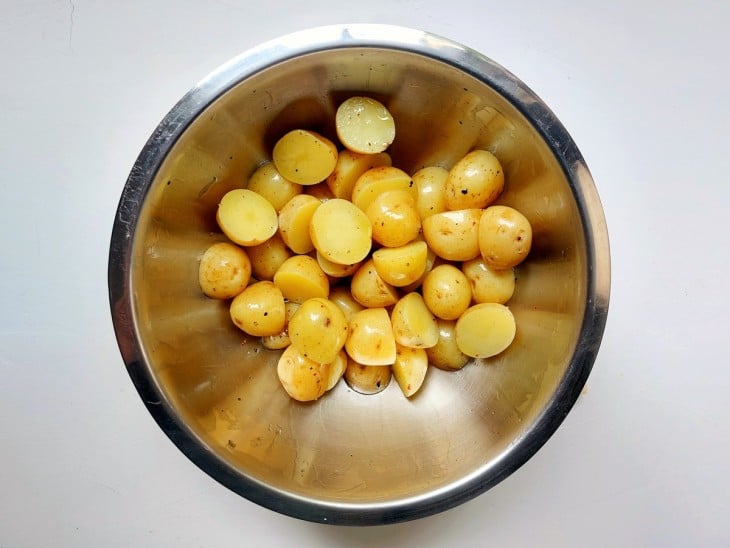 Um recipiente contendo batatas-bolinhas temperadas.