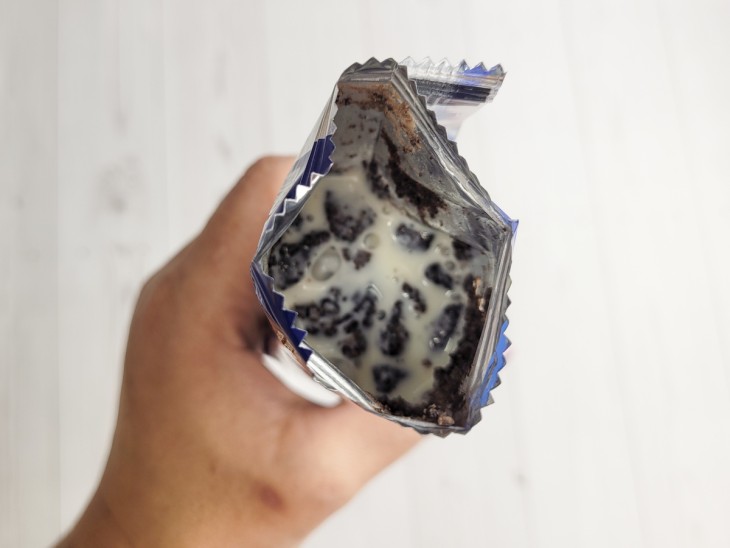 Um pacotinho de bolacha Oreo aberto com o creme dentro.