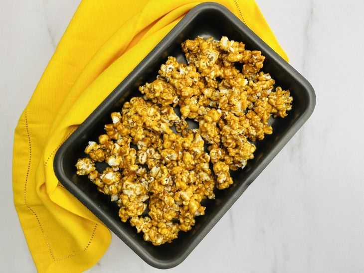 Um recipiente contendo pipoca caramelizada.