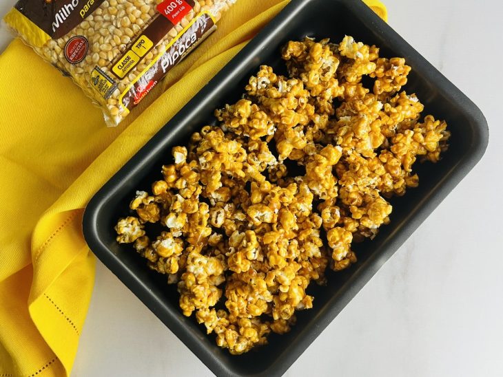 Um recipiente contendo pipoca caramelizada.