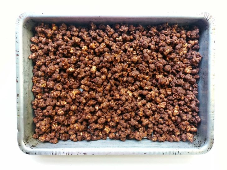 Uma forma com pipoca e cobertura de chocolate.