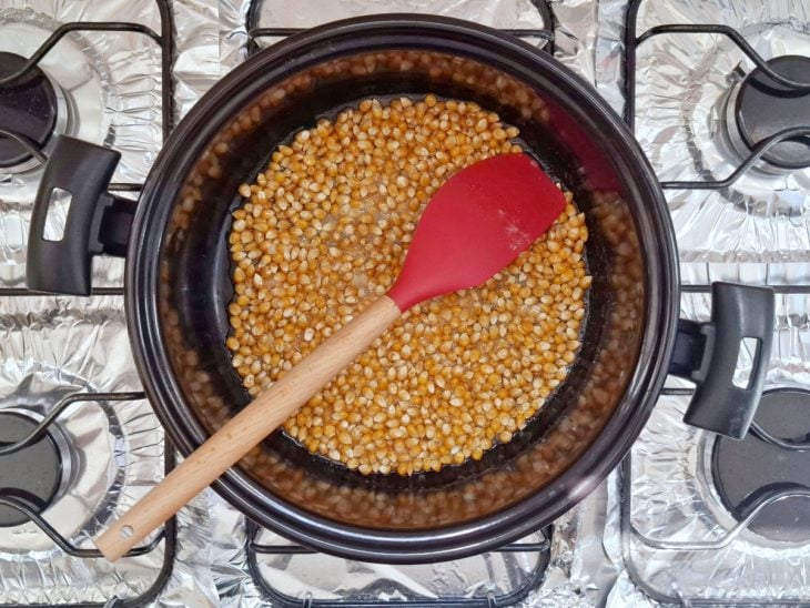 Pipoca, açúcar, óleo e água em uma panela.
