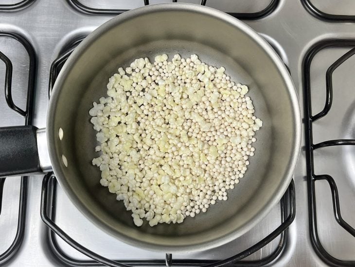 Uma panela ao fogo com azeite e sagu estourando.
