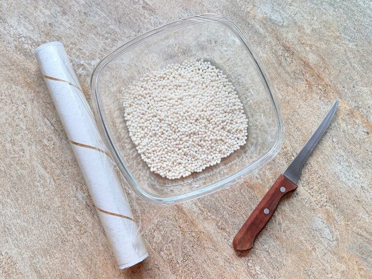 Parte do sagu colocada no recipiente coberto com papel-filme furado.