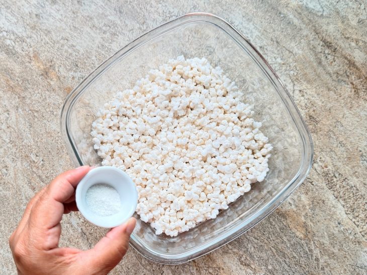 Pipoca de sagu finalizada sendo polvilhada com sal.