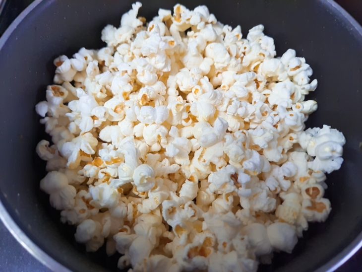 Uma panela com a pipoca estourada.