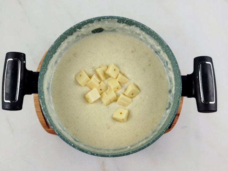 Queijo coalho em cubos adicionado na panela.